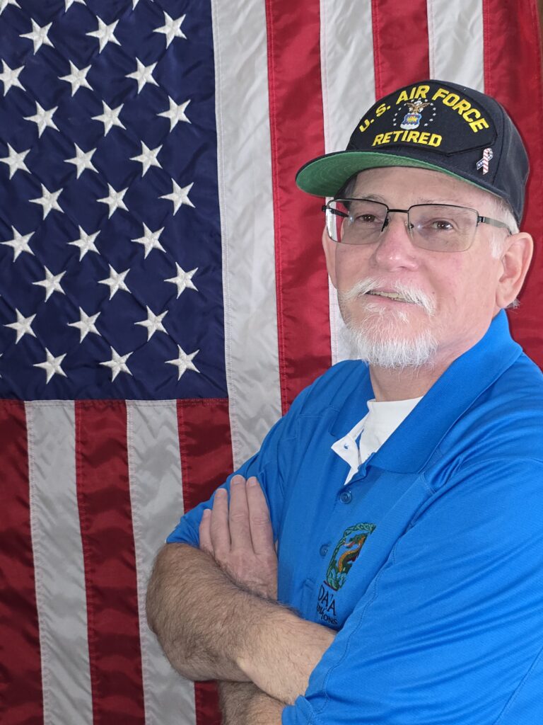 Co-Founder Steve in his Oaklea Media Solutions Shirt and his US Air Force Retired hat in front of the Stars and Stripes